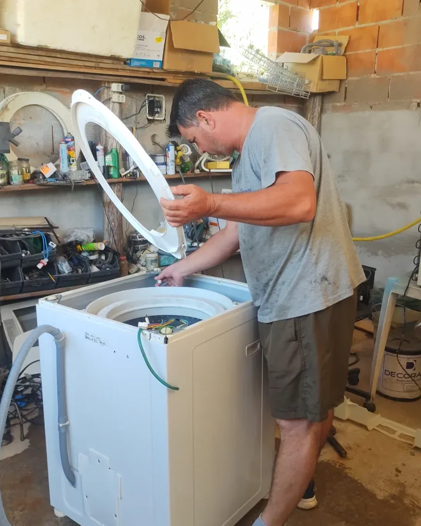 Técnico da Benassi desmontando uma máquina de lavar na bancada